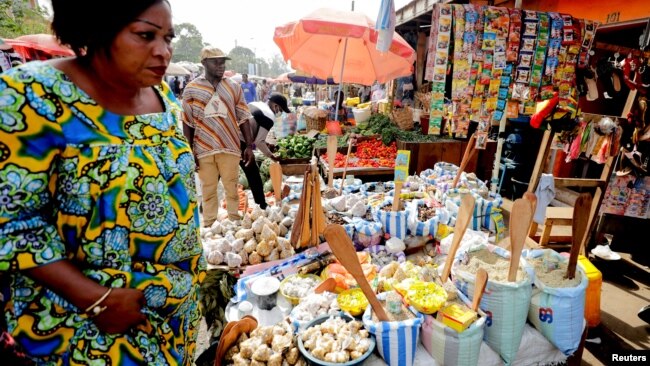 FILE - A woman shops at the Mvog Ada market in Yaounde, Cameroon, Jan. 29, 2022. President Paul Biya has for the first time sent a delegation to Europe to try to encourage well-off Cameroonians living there to invest back home.