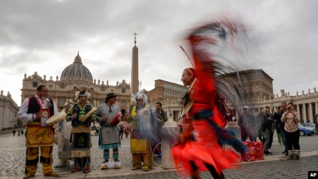 FILE - Assembly of First Nations members perform in St. Peter's Square at the Vatican on March 31, 2022. The Canadian government said Monday it had signed a $15.5 billion agreement to compensate First Nations children and families harmed by chronic underfunding of child welfare.