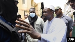 FILE: Senegalese opposition figure Ousmane Sonko discuss with members of the police outside his residence in Dakar on June 17, 2022.