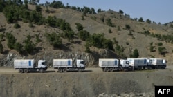 FILE - World Food Program (WFP) trucks wait to return after delivering humanitarian aid for the earthquake affected people in the Afghan-Dubai village of Spera district in Khost province, June 26, 2022.