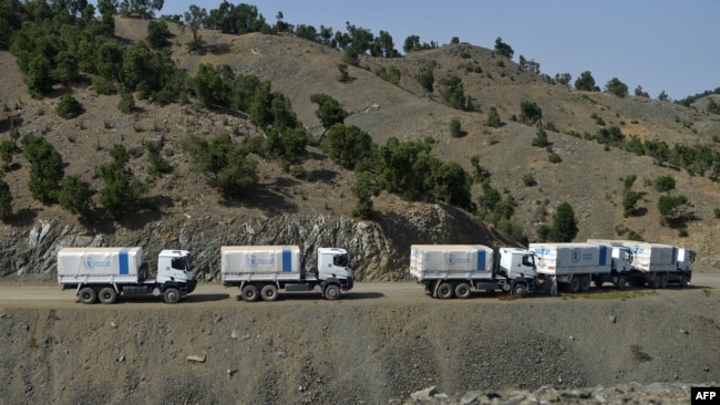 FILE - World Food Program (WFP) trucks wait to return after delivering humanitarian aid for the earthquake affected people in the Afghan-Dubai village of Spera district in Khost province, June 26, 2022.