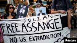 Para pengunjuk rasa di Athena, Yunani, memegang spanduk dalam aksi protes menentang ekstradisi pendiri WikiLeaks Julian Assange dari Inggris ke AS, 20 Juni 2022.