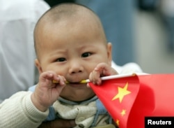 Seorang bayi Tionghoa memegang bendera nasional di Lapangan Tiananmen di Ibu Kota China, Beijing. (Foto: Reuters)