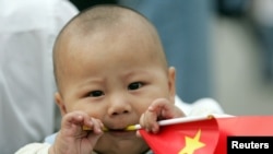 一個中國幼兒手拿一面中國國旗。