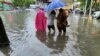 Pedestrians wade through floodwaters amid heavy rainfall as Typhoon Chaba hits Sanya in Hainan province, China, on July 2, 2022. Forecasters said the typhoon weakened into a tropical storm on Monday, but heavy rain is expected in central and eastern China in coming days
