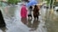 Pedestrians wade through floodwaters amid heavy rainfall as Typhoon Chaba hits Sanya in Hainan province, China, on July 2, 2022. Forecasters said the typhoon weakened into a tropical storm on Monday, but heavy rain is expected in central and eastern China in coming days
