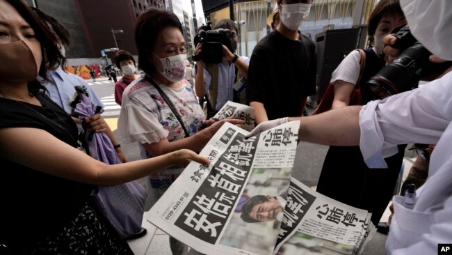 Extra editions of the Yomiuri Shimbun newspaper report on the shooting of Japan's former Prime Minister Shinzo Abe on July 8, 2022.(AP Photo/Eugene Hoshiko)