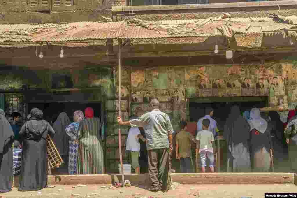 Families wait for loaves of subsidized bread. The World Bank says its loan will finance a month&rsquo;s worth of imported wheat for Egypt&rsquo;s bread subsidy program, which supports around 70 million low-income Egyptians. Cairo, July 7, 2022. (Hamada Elrasam/VOA)