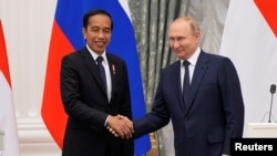 Presiden Rusia Vladimir Putin berjabat tangan dengan Presiden Indonesia Joko Widodo saat konferensi pers bersama setelah pertemuan mereka di Moskow, Rusia 30 Juni 2022. (Alexander Zemlanichenko/Pool via REUTERS)