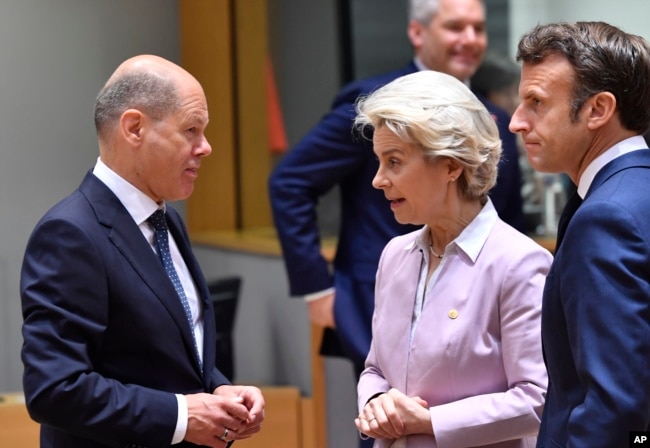 European Commission President Ursula von der Leyen, center, and French President Emmanuel Macron, right, speak with German Chancellor Olaf Scholz during a round table meeting at an EU summit in Brussels, Thursday, June 23, 2022. (AP Photo/Geert Vanden Wijngaert)