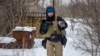 FILE - Ukrainian photographer Maks Levin carries a cat near the line of separation from Russian-backed separatists in Donetsk region, Ukraine, Jan 25, 2022.