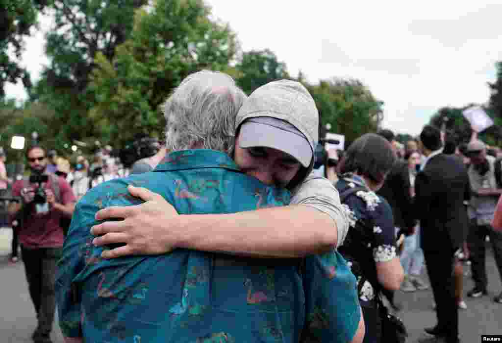 Dos hombres celebran con un abrazo la decisión de la Corte Suprema.