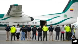 La policía presenta a los medios de comunicación a cinco personas acusadas del asesinato del fiscal de Paraguay para casos de crimen organizado y narcotráfico, Marcelo Pecci, en la pista de un aeropuerto en Bogotá, Colombia, el miércoles 8 de junio de 2022. 