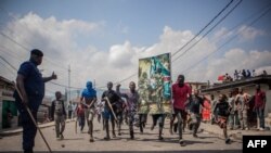 Des manifestants portent une affiche honorant les forces armées de la RDC lors d'une manifestation à Goma, le 15 juin 2022.