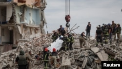 Rescuers extract a body from a residential building damaged by a Russian military strike in the town of Chasiv Yar, in Donetsk region, Ukraine, July 10, 2022. 