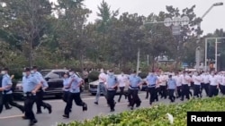 资料照：中国警察跑向河南郑州中国人民银行支行前抗议银行冻结存款的储户们。（2022年7月10日）