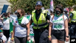 Abortion-rights activists demonstrating against the Supreme Court decision to overturn Roe v. Wade, submit themselves to arrest by Capitol Police after blocking a street on Capitol Hill in Washington, Thursday, June 30, 2022. 