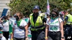 Pendemo yang mendukung hak aborsi, yang menggelar aksi di dekat gedung Mahkamah Agung AS, menyerahkan diri kepada polisi yang berjaga di lokasi sekitar demonstrasi di Washington, pada 30 Juni 2022. (Foto: AP/J. Scott Applewhite)