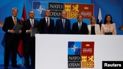 Lideri i šefovi diplomatija Turske, Finske i Švedske sa generalnim sekretarom NATO-a Jensom Stoltenbergom poslije potpisivanja memoranduma u Madridu (Foto: REUTERS/Yves Herman)