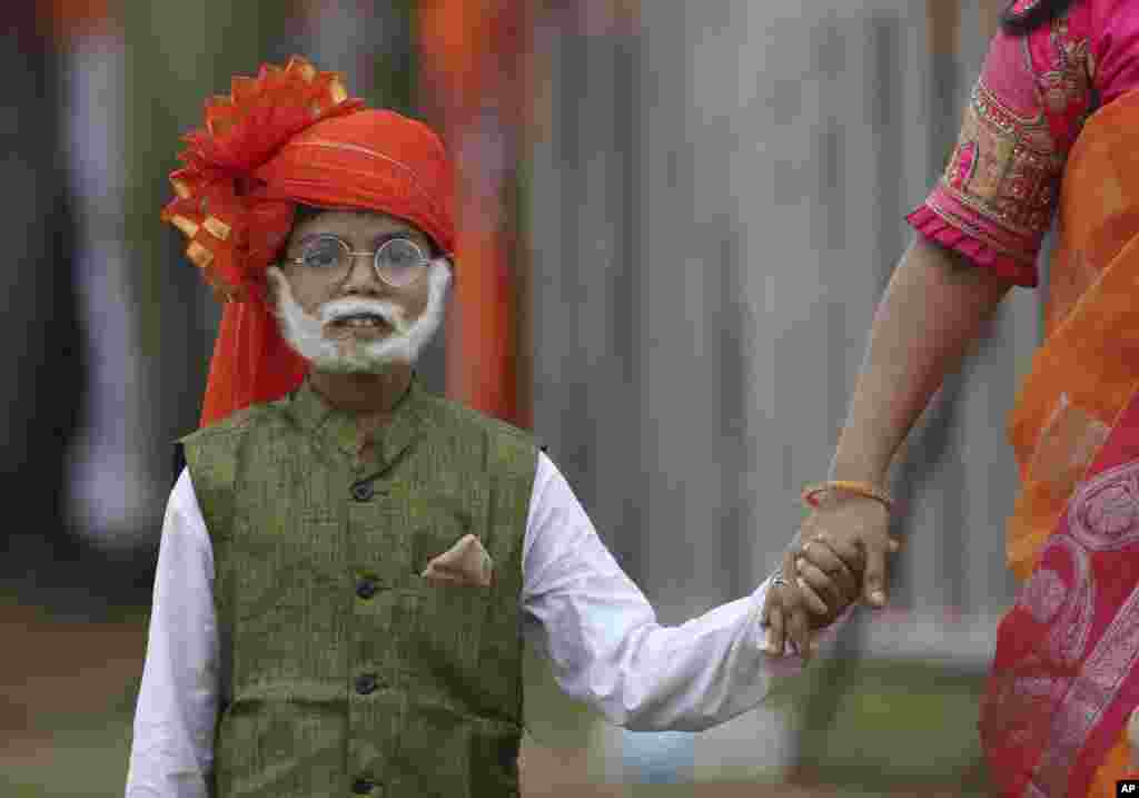 A young supporter of ruling Bharatiya Janata Party (BJP) dressed like Indian Prime Minister Narendra Modi arrives with his mother during a public meeting addressed by Modiin Hyderabad.
