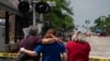 Satu keluarga tampak memeluk satu sama lain ketika mengamati lokasi penembakan massal pawai Hari Kemerdekaan di Highland Park, Illinois, pada 5 Juli 2022. (Foto: AFP/Max Herman)