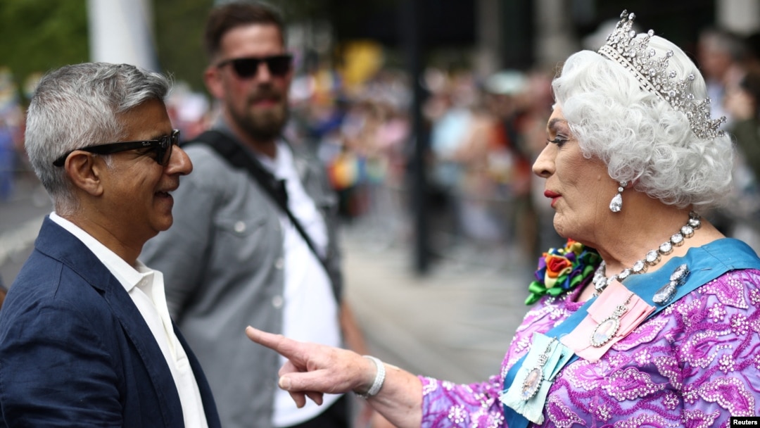 London Mayor Sadiq Khan talks to a person dressed as a queen, at the 2022 Pride Parade in London, July 2, 2022.