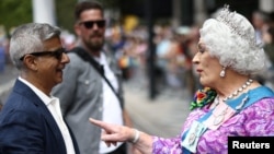 London Mayor Sadiq Khan talks to a person dressed as a queen, at the 2022 Pride Parade in London, July 2, 2022.