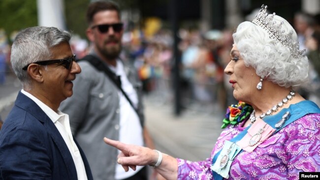 London Mayor Sadiq Khan talks to a person dressed as a queen, at the 2022 Pride Parade in London, July 2, 2022.