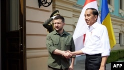 Presiden Ukraina Volodymyr Zelenskyy (kiri) dan Presiden Joko Widodo berjabat tangan dalam pertemuan di Kyiv, Ukraina Rabu 29 Juni 2022. 