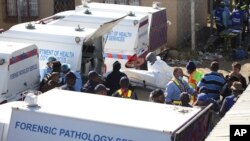 FILE: A body is removed from a nightclub in East London, South Africa, 6.26.2022