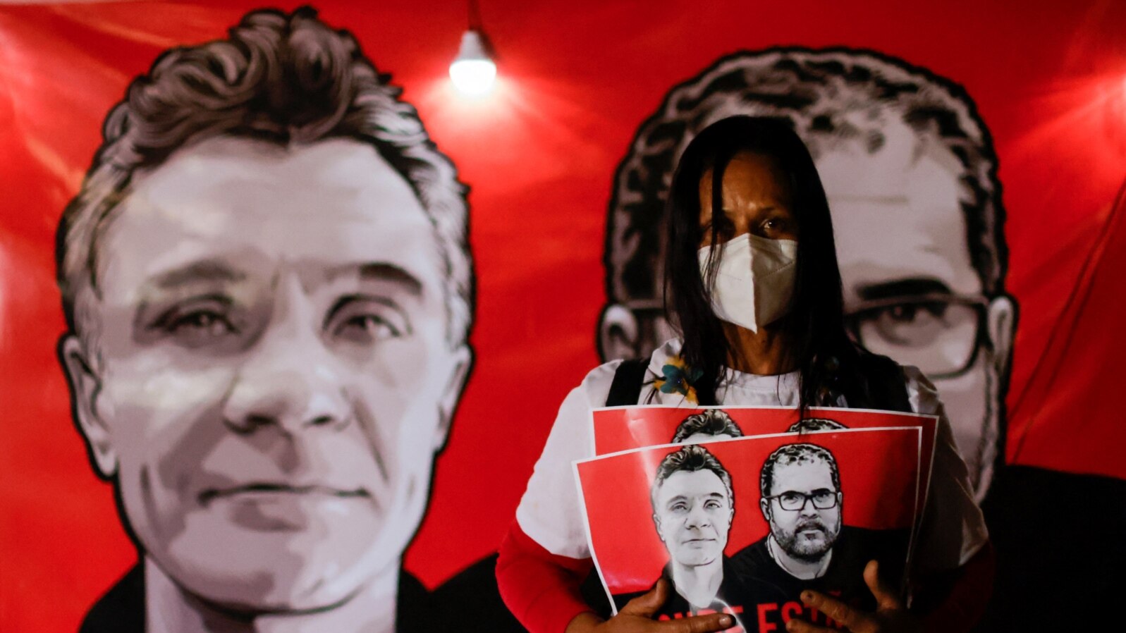 A demonstrator holds a sign with images of British journalist Dom Phillips and indigenous expert Bruno Pereira, during a protest against Brazilian President Jair Bolsonaro's government in Brasilia, Brazil June 15, 2022. 