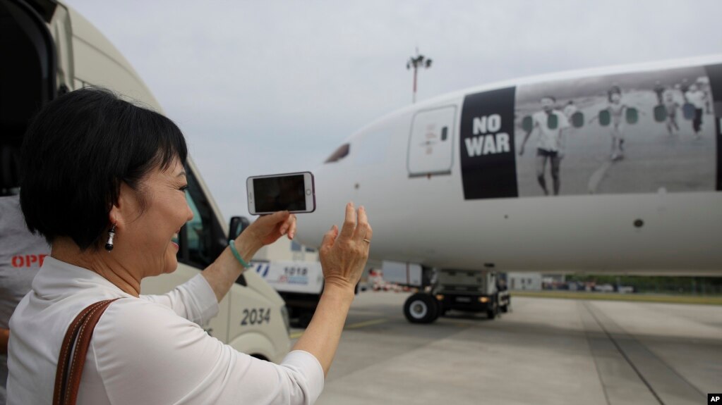 著名越战新闻照片中的女孩潘金福护送乌克兰难民搭乘印有那张照片的人道主义航班从波兰华沙前往加拿大。(2022年7月4日)(photo:VOA)