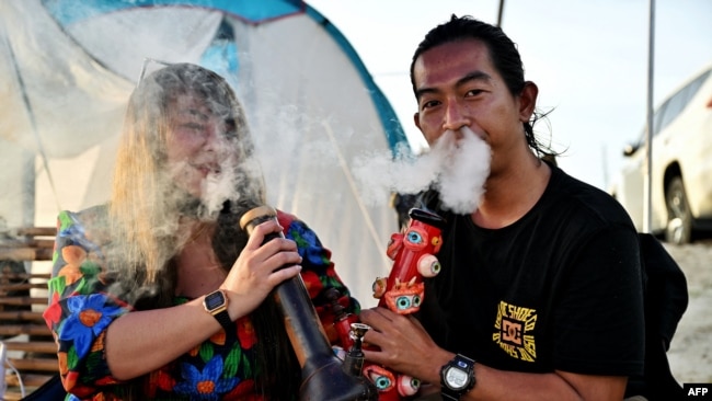 FILE - People smoke weed to celebrate the legalization of cannabis at the Thailand: 420 Legalaew! weekend festival hosted by Highland in Nakhon Pathom province on June 11, 2022.