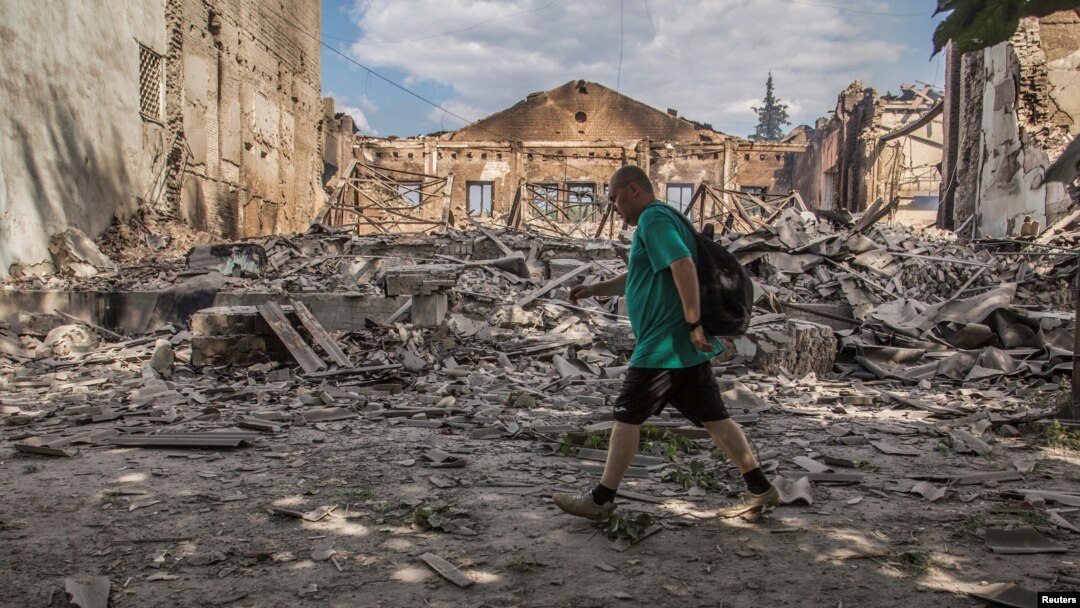 ARCHIVO - Un residente local camina frente a un edificio destruido por un ataque militar, en Lysychansk, región de Luhansk, Ucrania, el 17 de junio de 2022.