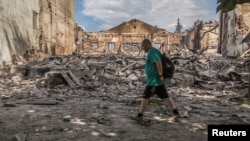 A man walks by a building destroyed by a military strike in Lysychansk, Luhansk region, Ukraine, on June 17, 2022. Ukrainian military leaders said Sunday they decided to withdraw forces from the city because battling Russia's bigger military 'would lead to fatal consequences.'