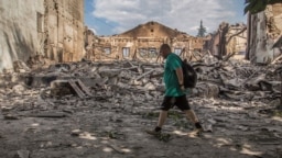 A man walks by a building destroyed by a military strike in Lysychansk, Luhansk region, Ukraine, on June 17, 2022. Ukrainian military leaders said Sunday they decided to withdraw forces from the city because battling Russia's bigger military "would lead to fatal consequences."