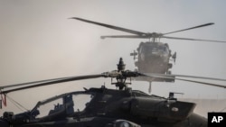 지난 2019년 시리아 동부 모처 미군 주둔지에서 블랙호크 헬리콥터가 아파치 공격 헬기 인근에 착륙하고 있다. (자료사진) 