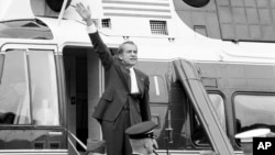 FILE - In this Aug. 9, 1974 file photo, President Richard Nixon waves goodbye from the steps of his helicopter outside the White House, after he gave a farewell address to members of the White House staff.