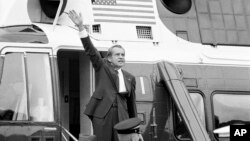 FILE - In this Aug. 9, 1974 file photo, President Richard Nixon waves goodbye from the steps of his helicopter outside the White House, after he gave a farewell address to members of the White House staff.