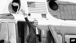 ARCHIVO - En esta foto de archivo del 9 de agosto de 1974, el presidente Richard Nixon se despide desde los escalones de su helicóptero afuera de la Casa Blanca, después de dar un discurso de despedida a los miembros del personal de la Casa Blanca.