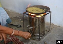 Manjulaben Parmar, warga desa Keinyal, sekitar 50 kilometer dari Ahmedabad, India, memasak roti di atas 'Kompor Memasak Bersih' yang disediakan oleh Asosiasi Wanita Wiraswasta (SEWA), 29 November 2012. (SAM PANTHAKY / AFP)