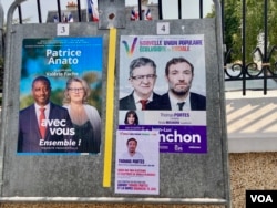 Posters at Neuilly Plaisance polling station featuring the local centirist and leftist candidates for France's National Assembly, or lower house. (Lisa Bryant/VOA)