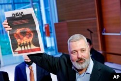 Dmitry Muratov, editor-in-chief of the influential Russian newspaper Novaya Gazeta, celebrates after auctioning off his 2021 23-karat gold medal Nobel Peace Prize at the Times Center, Monday, June 20, 2022, in New York. (AP Photo/Eduardo Munoz Alvarez)ttt