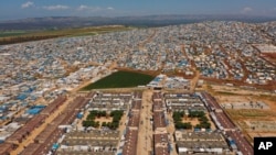 FILE - An aerial view shows a large refugee camp on the Syrian side of the border with Turkey, near Atma, in Idlib province, April 19, 2020. 