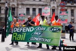 Anggota serikat pekerja RMT berunjuk rasa di luar Stasiun Victoria, pada hari pertama pemogokan kereta api nasional, di London, Inggris 21 Juni 2022. (REUTERS/John Sibley)