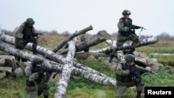 FILE - Marines of the Baltic Fleet forces of the Russian Navy train in a zone of obstacles during military exercises at the Khmelevka firing ground in Russia's Kaliningrad region, Nov. 24, 2021.