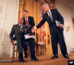 ARSIP - Presiden Clinton dan Wakil Presiden Al Gore (belakang), bersama Herman Shaw (94), korban Studi Sifilis Tuskegee, dalam konferensi pers, 16 Mei 1997. (Foto AP/Doug Mills, File)