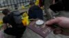Демонстрант держит российский паспорт со свечой и нарциссом во время антивоенной акции памяти жертв боевых действий в Украине перед посольством Украины в Тбилиси, Грузия, 3 апреля 2022 г. (AP Photo/Vasily Krestyaninov )