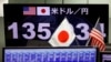 ARCHIVO: Un monitor que muestra el tipo de cambio del yen japonés frente al dólar estadounidense se ve a través de las banderas nacionales de EEUU y Japón en la empresa de comercio de divisas Gaitame.com en Tokio, Japón, el 13 de junio de 2022 REUTERS/Issei Kato/Foto de archivo