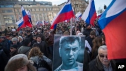 Manifestants tenant un portrait du chef de l'opposition Boris Nemtsov pendant une cérémonie à Moscou marquant le premier anniversaire de son assassinat le samedi 27 février 2016. (AP/ Ivan Sekretarev)